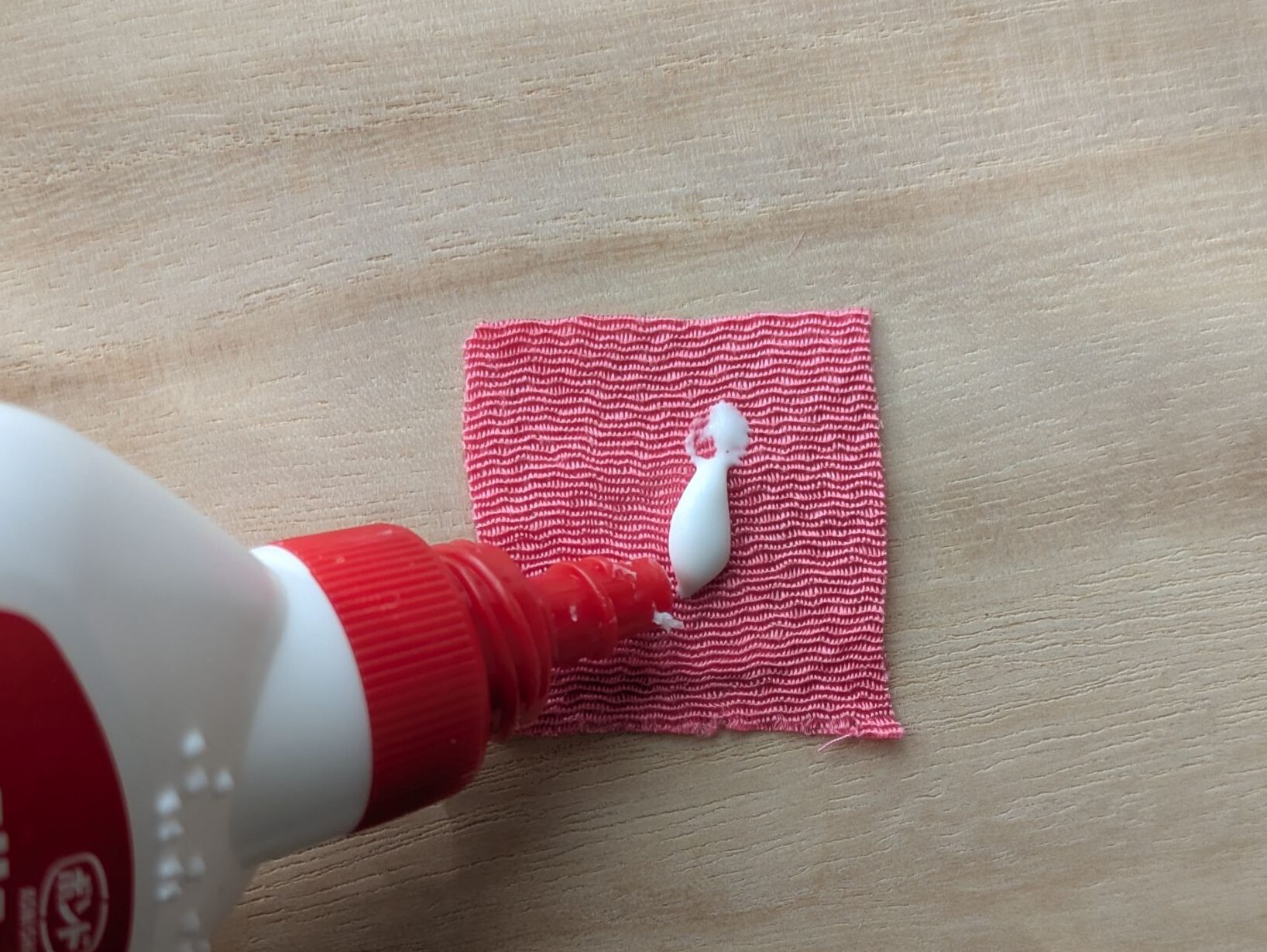 ピンクの布にボンドを塗る