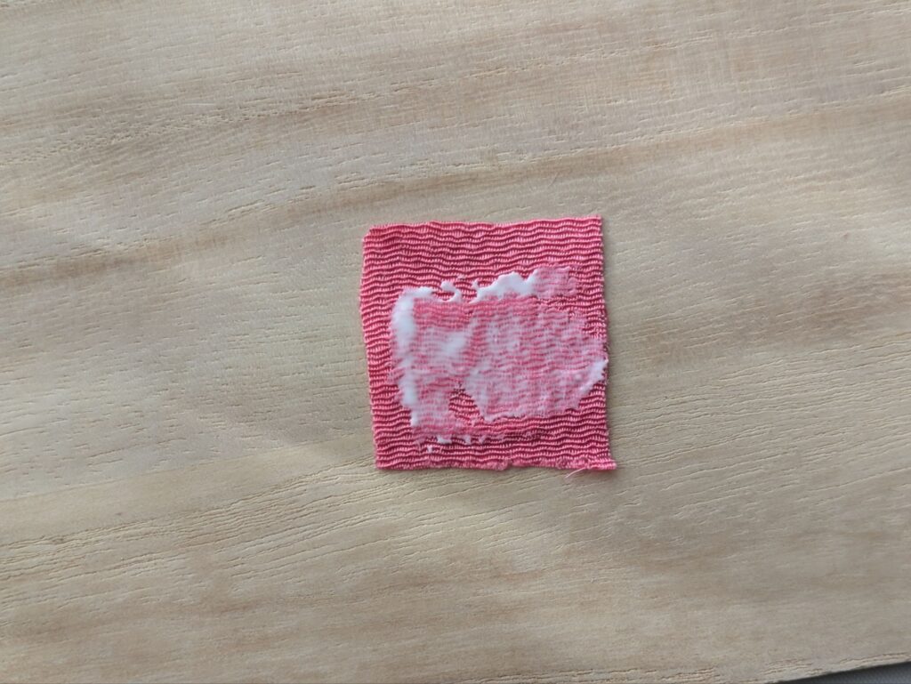 ピンクの布にボンドを塗り拡げた状態