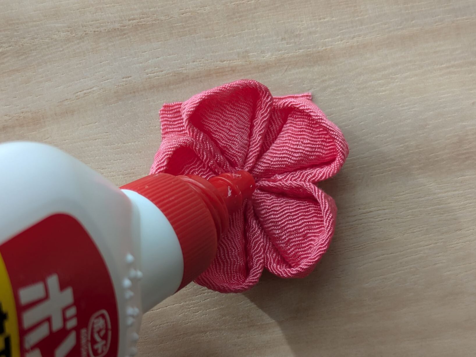 ピンクの花の中心にボンドをのせるところ