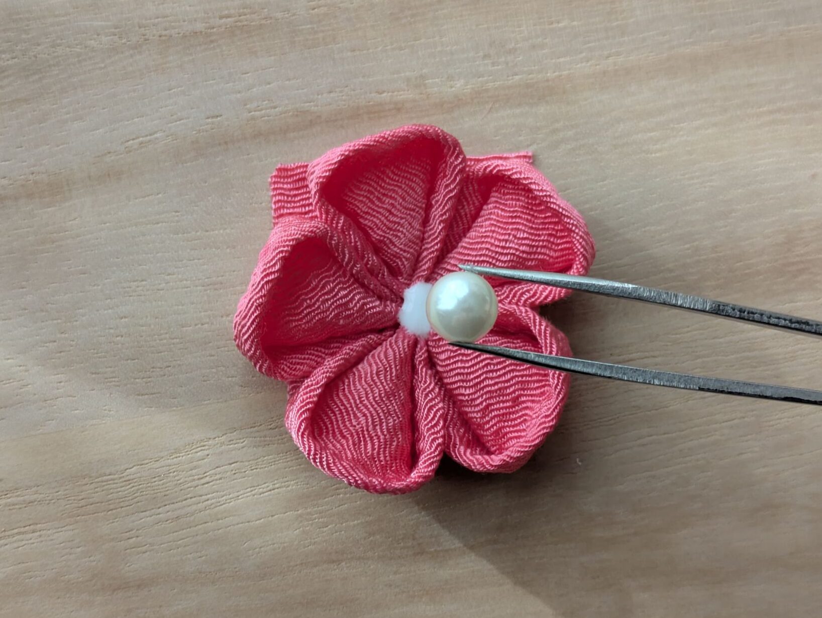 ピンクの花の中心にパールを置くところ