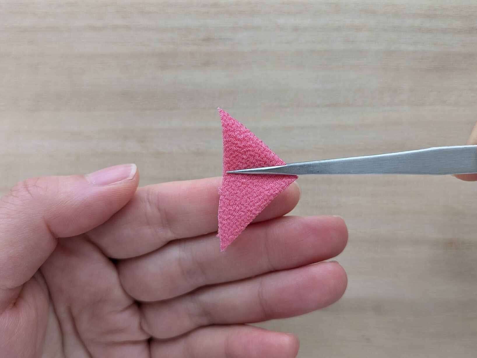 ピンクの三角形の布をさらに折ったところ