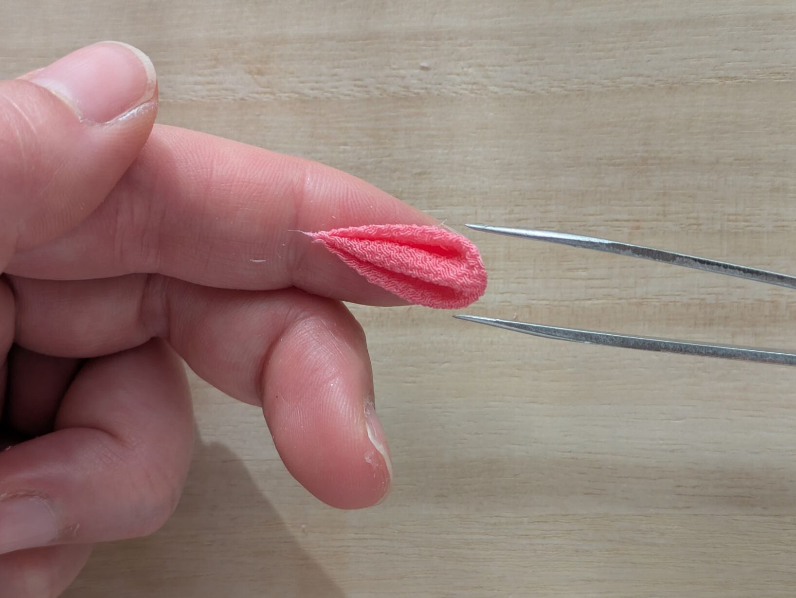 ピンクの丸つまみを指に乗せている