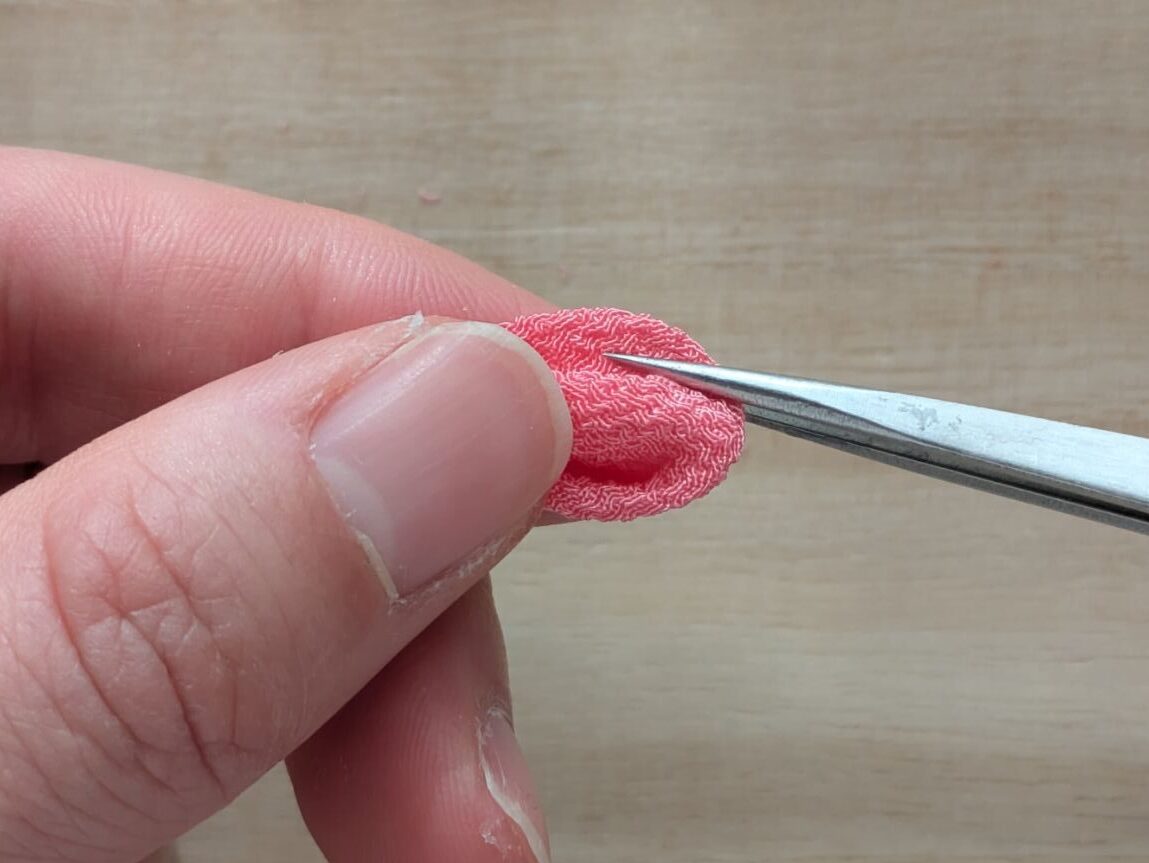 ピンクの丸つまみの丸み側の左端を持っている