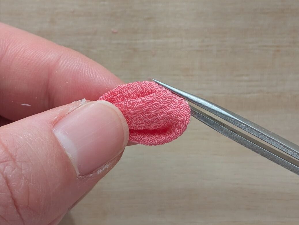 ピンクの丸つまみの丸み側の左端を押し出している