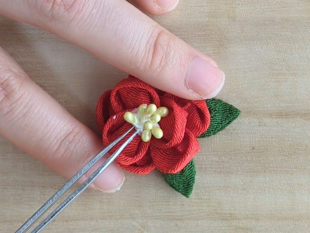 椿の花の中心にペップを配置しているところ