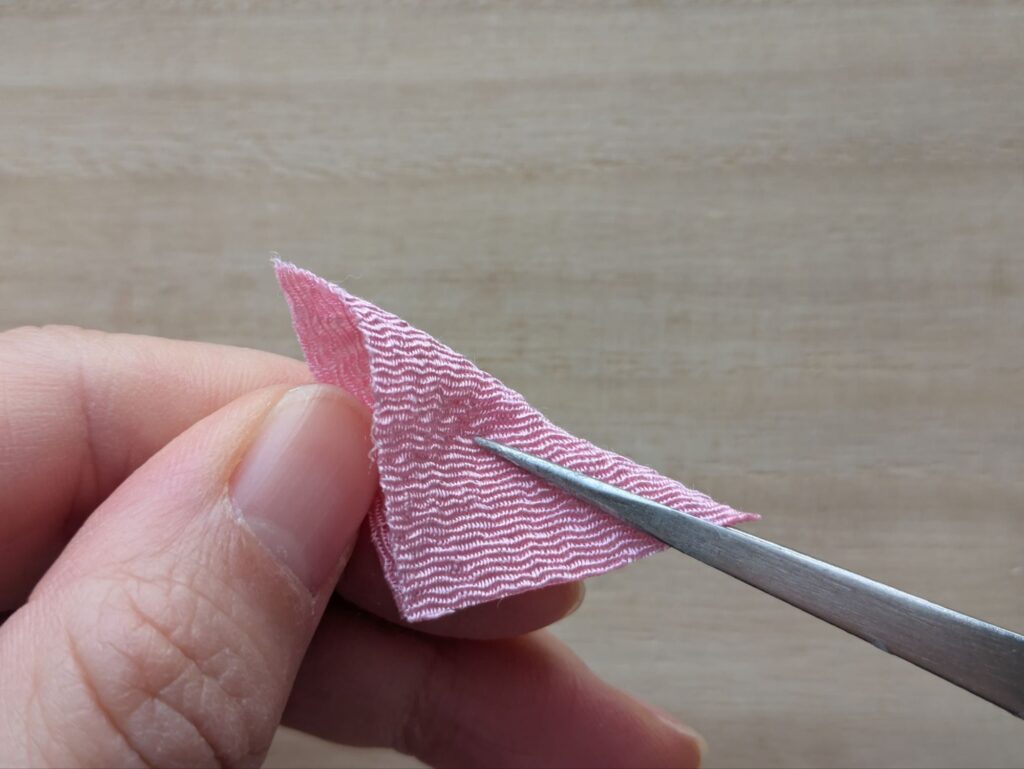 ピンクの布を三角に折る