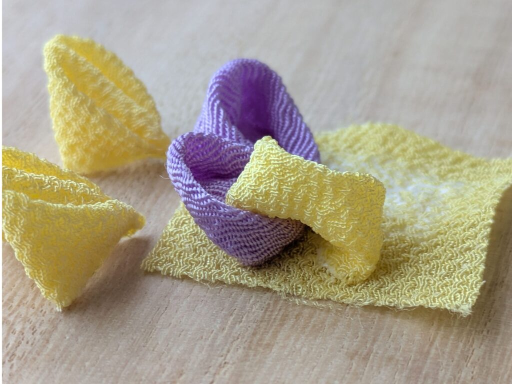 つまみ細工 パンジーの花びら小（黄）を紫の花びらに重ねて配置した工程（横からの写真）
