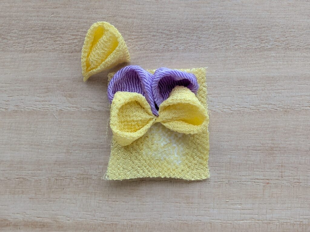 つまみ細工 パンジーの花びら小（黄）を紫の花びらに重ねて配置する工程