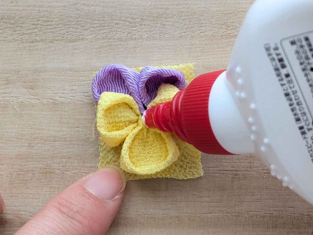 つまみ細工で作ったパンジーの花の中心にボンドを塗る工程