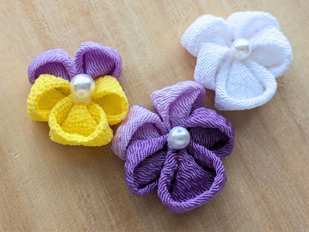 つまみ細工で作ったパンジーの完成写真紫と白と黄色の花