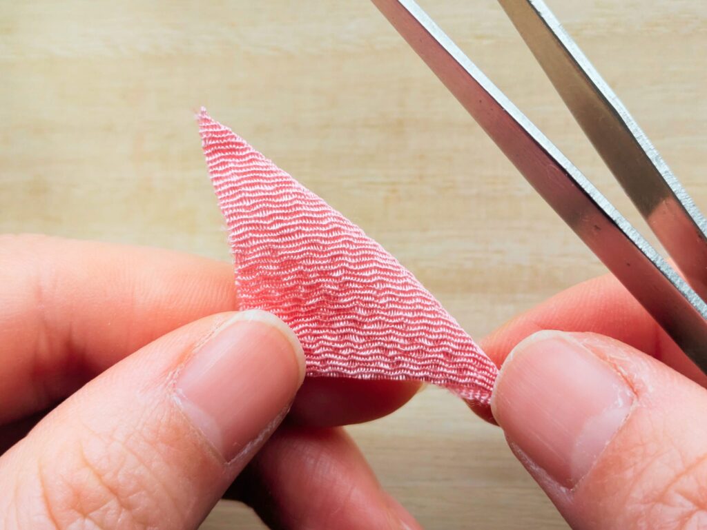 ピンクの布を半分に折っている