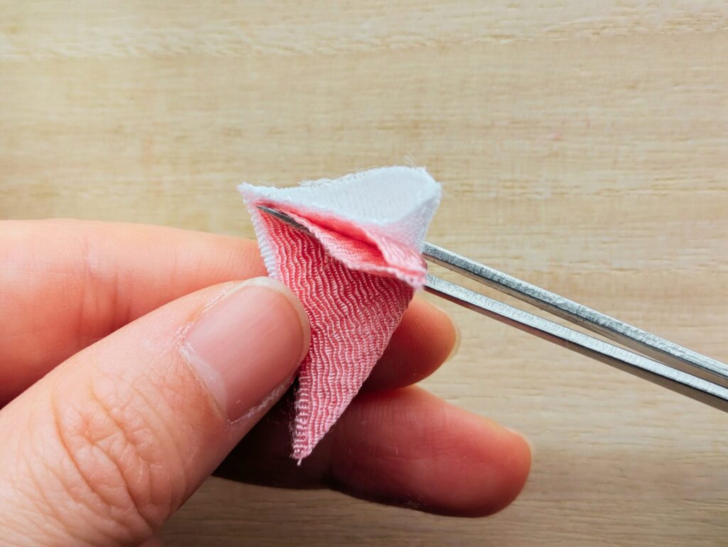 重ねた三角の布をさらに三角に折る